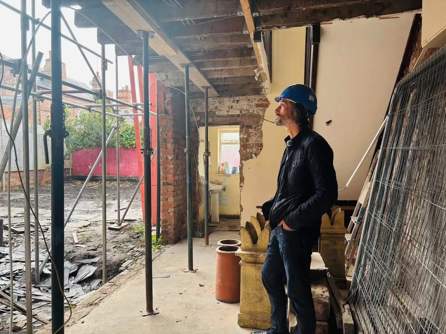 Rob Stewart on site during a property development, standing beneath propped joists and exposed brickwork